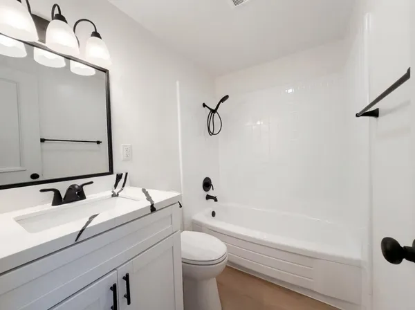 a bathroom with a granite countertop sink a toilet and shower