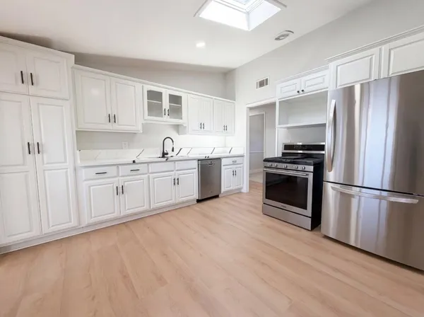 a kitchen with stainless steel appliances granite countertop a refrigerator and a sink