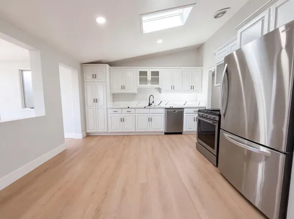 a large kitchen with a refrigerator sink and stove