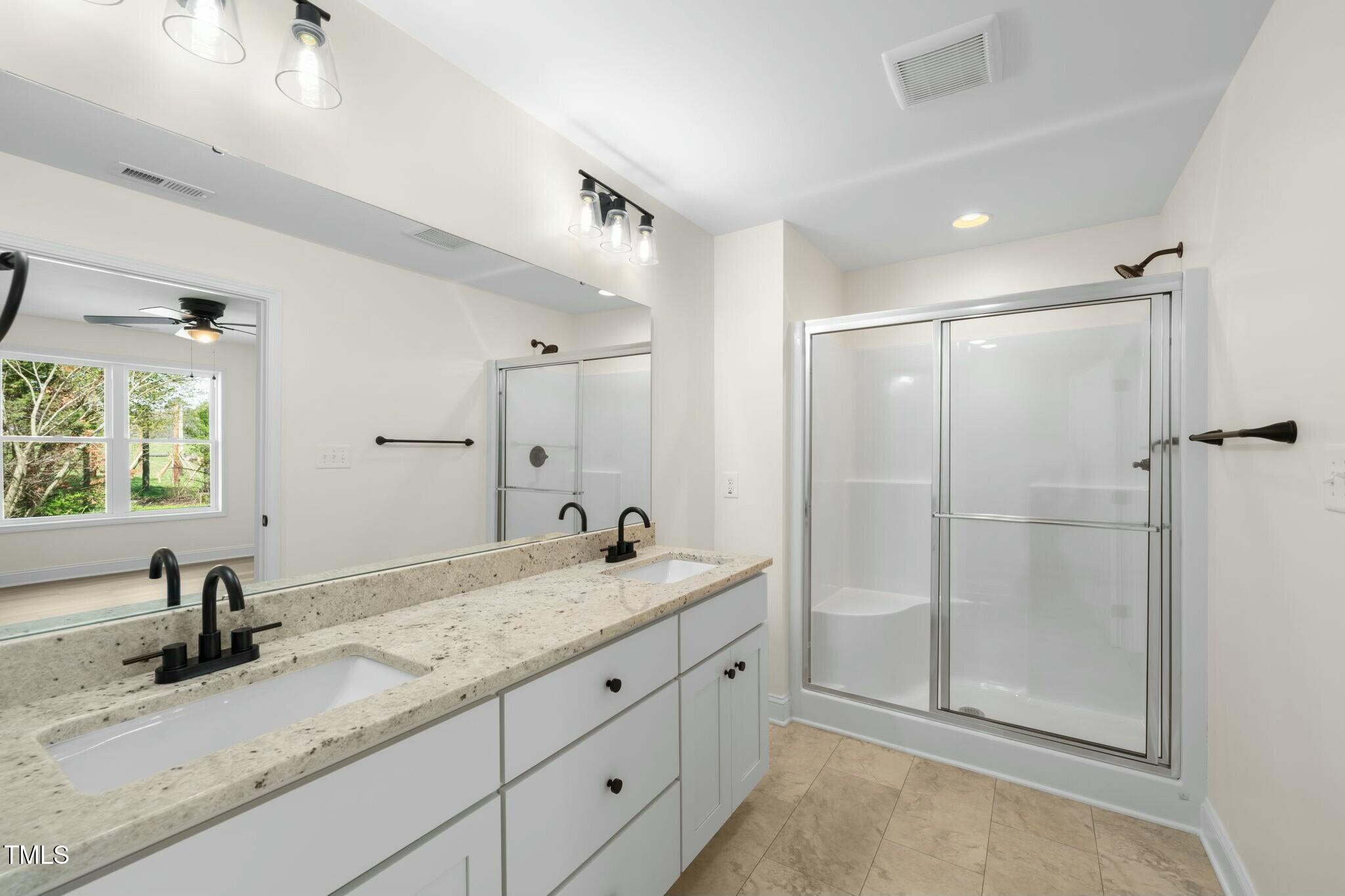 8917 Fowler Road Zebulon, NC 27597 - Photo 11 of 33 a bathroom with double sink and a mirror