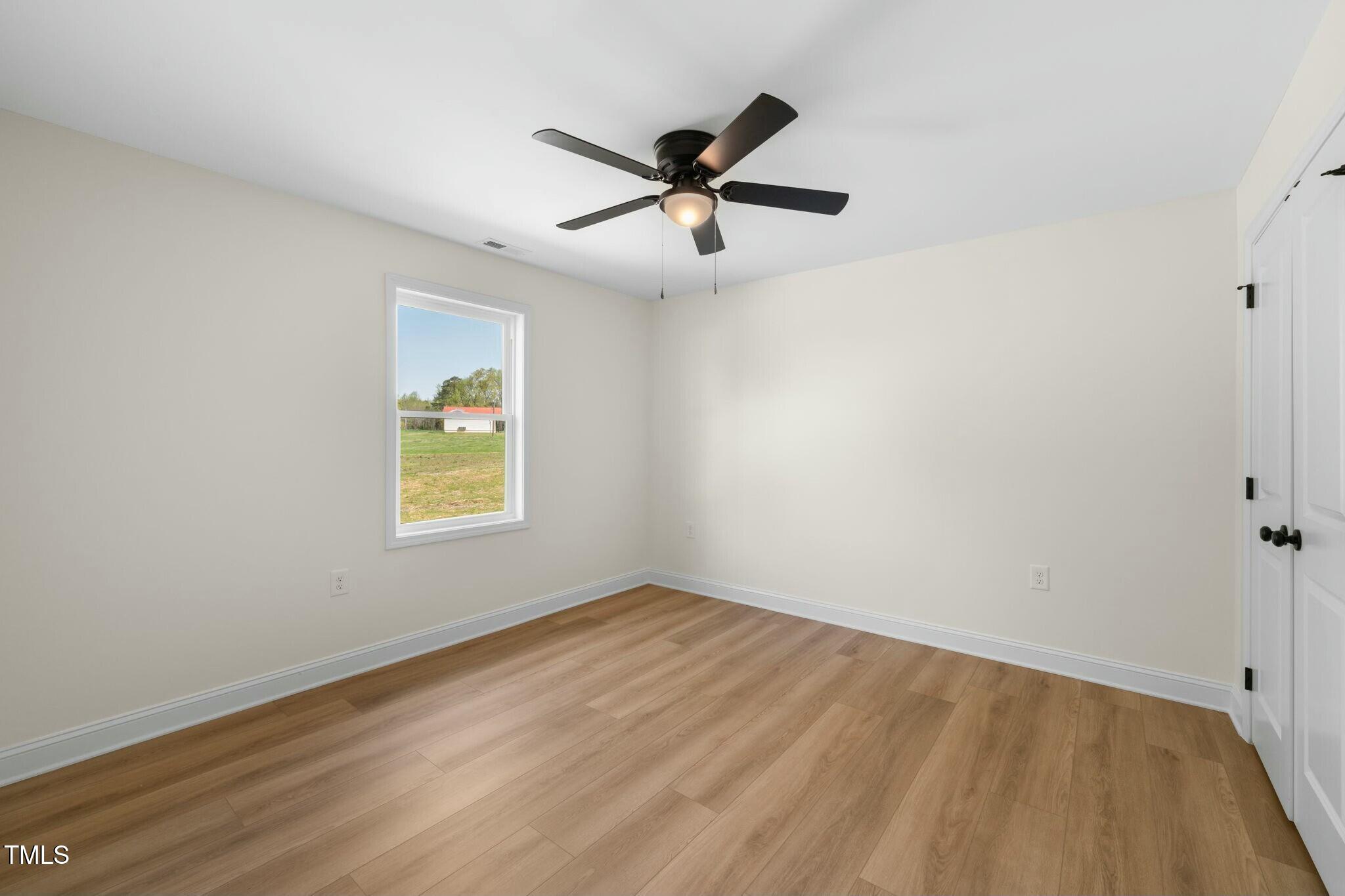 8917 Fowler Road Zebulon, NC 27597 - Photo 13 of 33 an empty room with window and ceiling fan