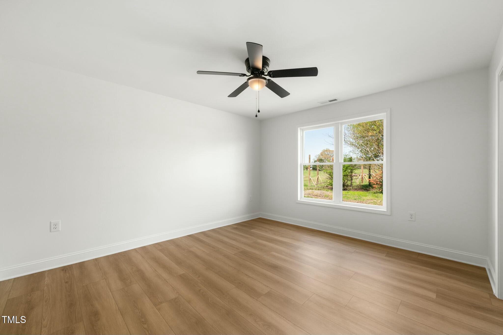 8917 Fowler Road Zebulon, NC 27597 - Photo 18 of 33 wooden floor in an empty room with a window