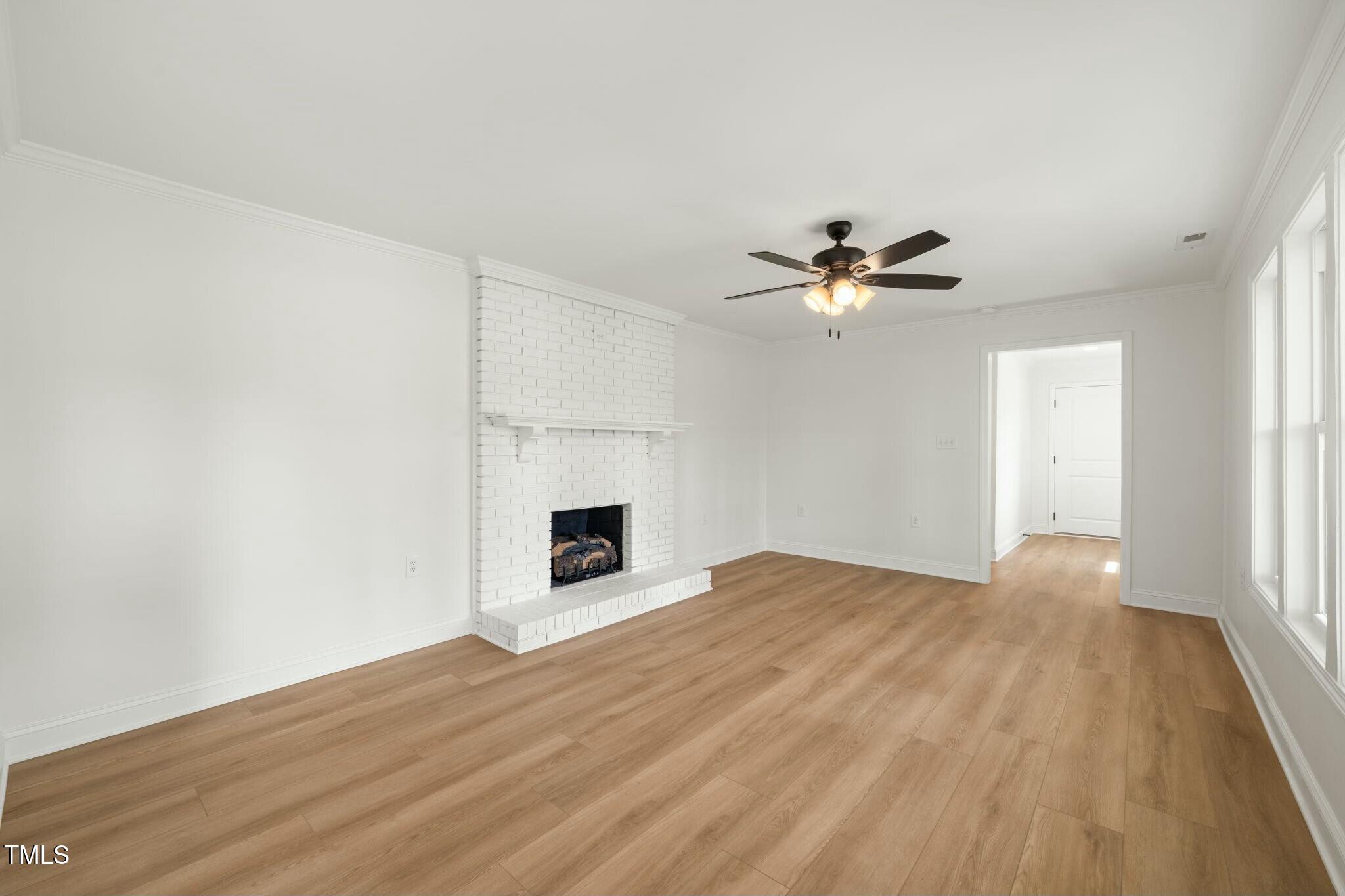 8917 Fowler Road Zebulon, NC 27597 - Photo 22 of 33 a view of an empty room with wooden floor and a ceiling fan