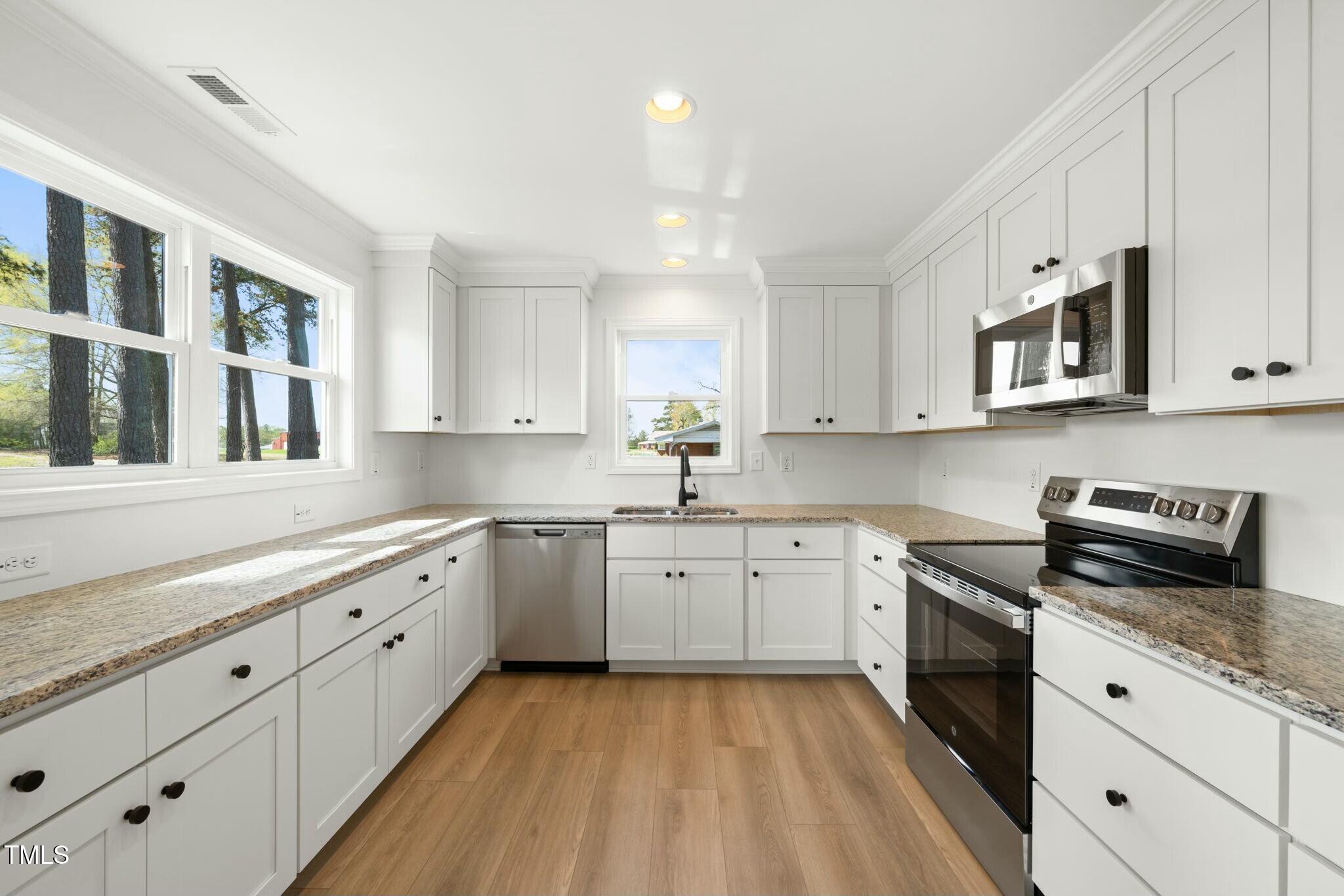 8917 Fowler Road Zebulon, NC 27597 - Photo 25 of 33 a kitchen with granite countertop cabinets stainless steel appliances a sink and a window