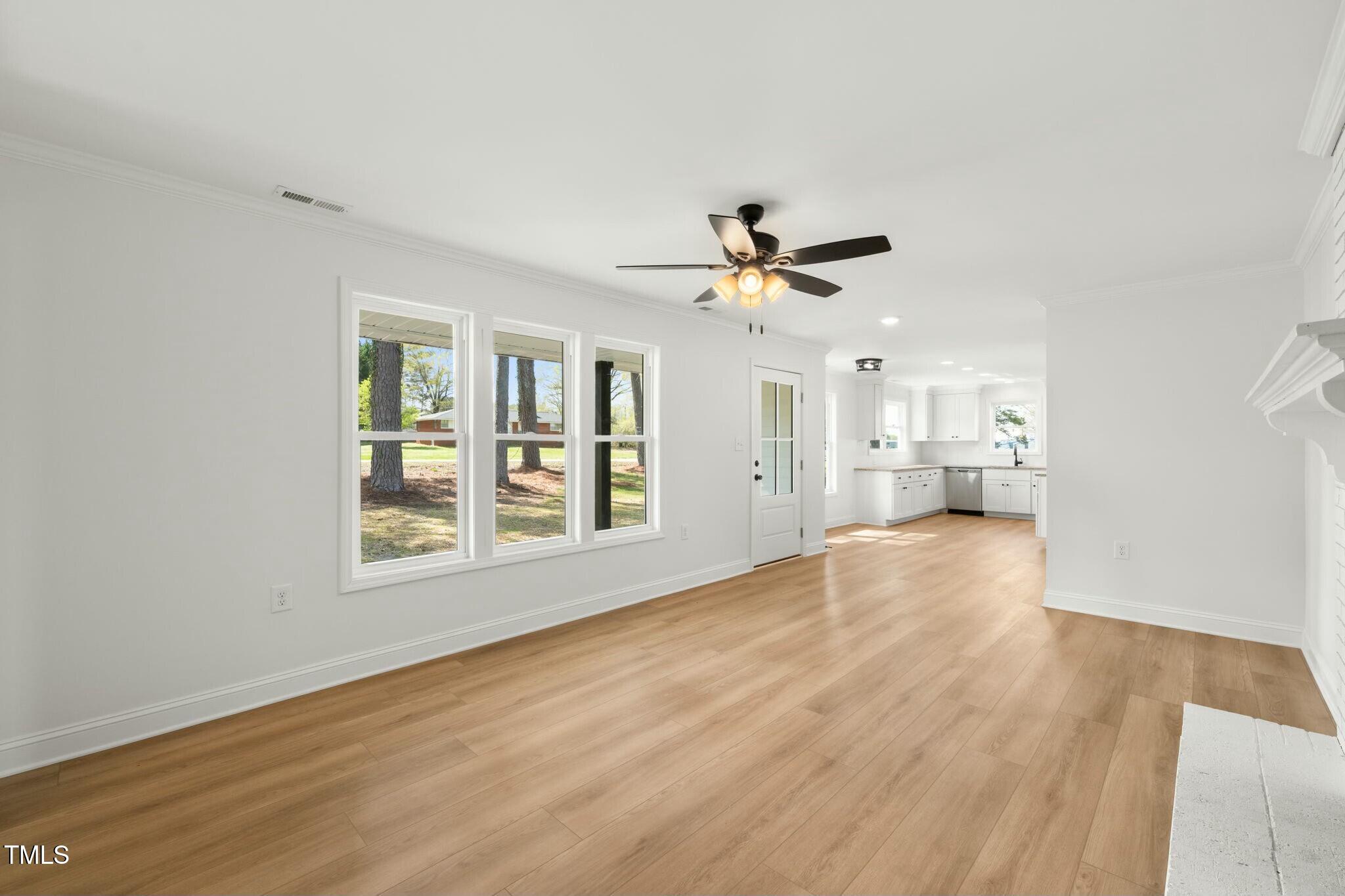 8917 Fowler Road Zebulon, NC 27597 - Photo 27 of 33 a view of an empty room with a window and wooden floor