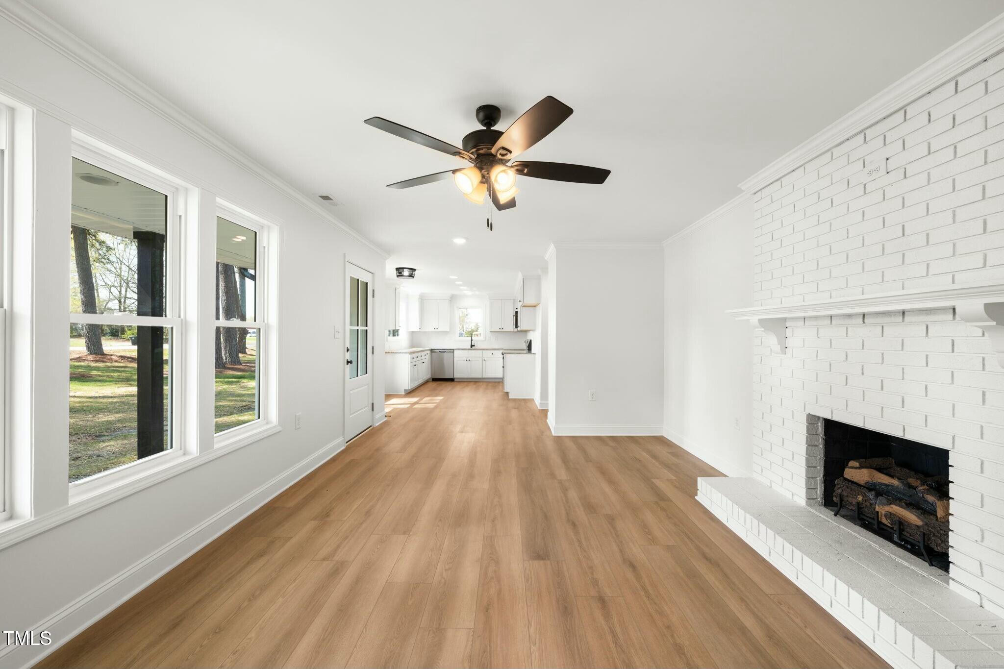 8917 Fowler Road Zebulon, NC 27597 - Photo 28 of 33 a view of a kitchen with furniture a ceiling fan and wooden floor