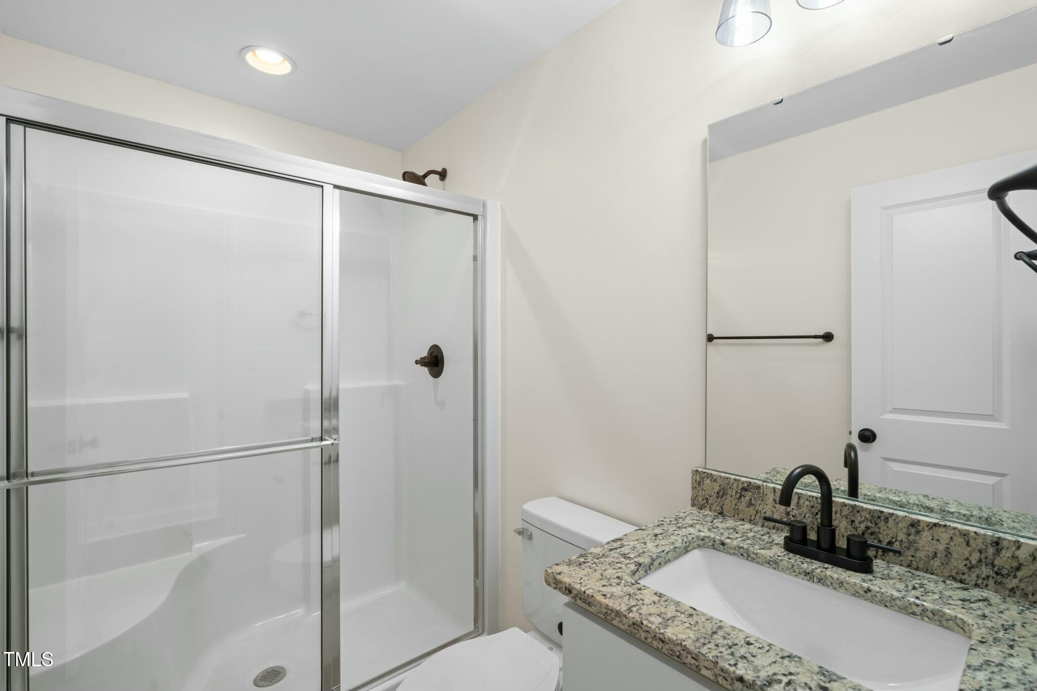 8917 Fowler Road Zebulon, NC 27597 - Photo 7 of 33 a bathroom with a granite countertop sink toilet and shower