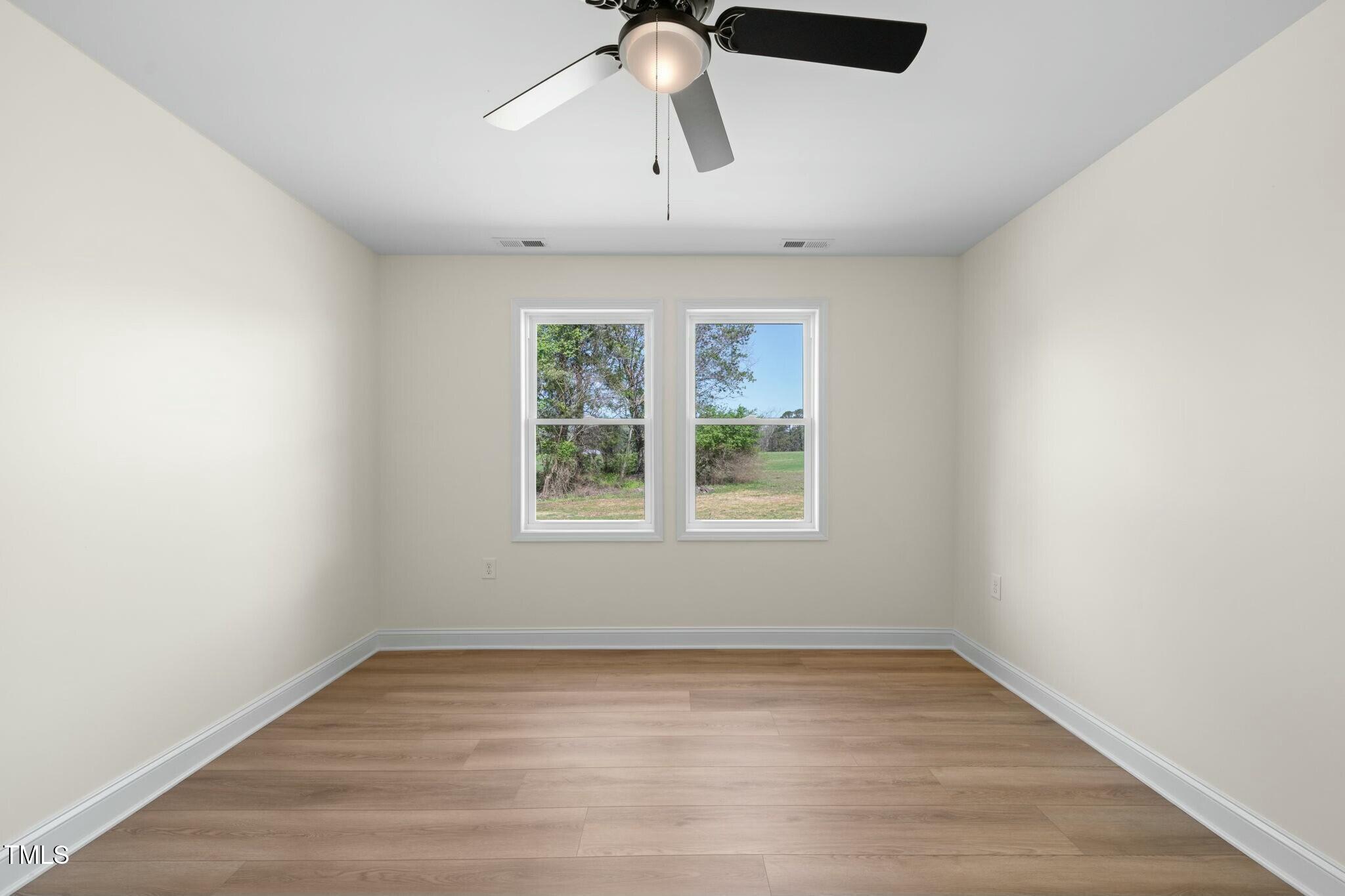 8917 Fowler Road Zebulon, NC 27597 - Photo 9 of 33 wooden floor in an empty room with a window