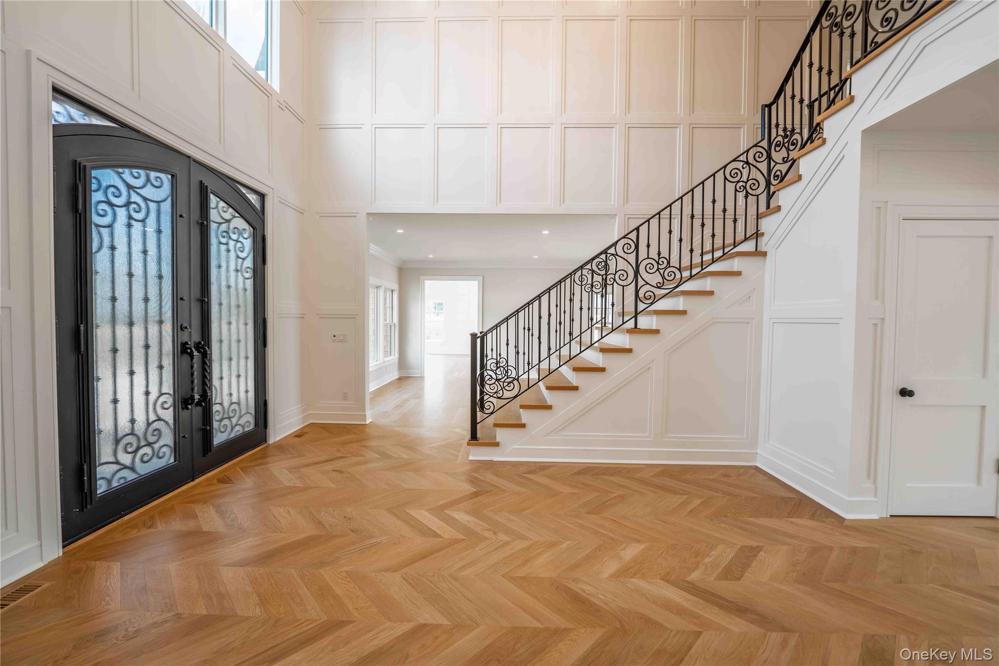 106 Cove Road Asharoken, NY 11768 - Photo 4 of 46 Foyer featuring french doors, parquet floors, a decorative wall, a high ceiling, and arched walkways