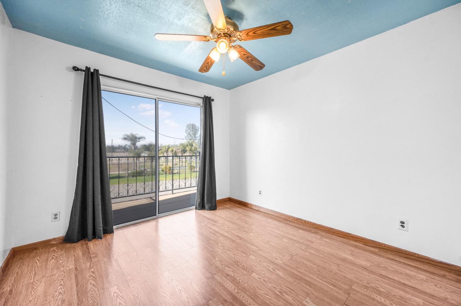 31334 Donald Avenue Madera, CA 93636 - Photo 21 of 38 a view of a bedroom with wooden floor and a ceiling fan