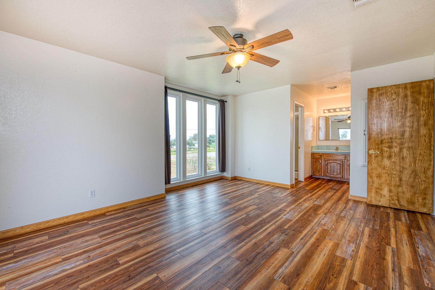 31334 Donald Avenue Madera, CA 93636 - Photo 23 of 38 a view of an empty room with wooden floor and a window