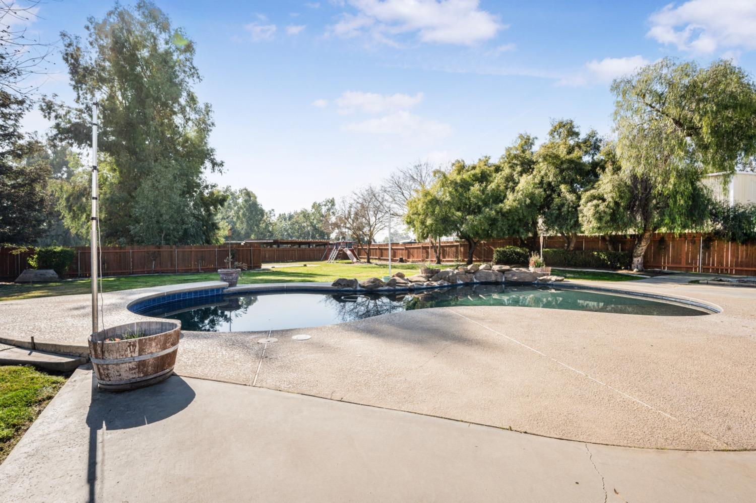 31334 Donald Avenue Madera, CA 93636 - Photo 30 of 38 a view of a swimming pool with a bench and trees