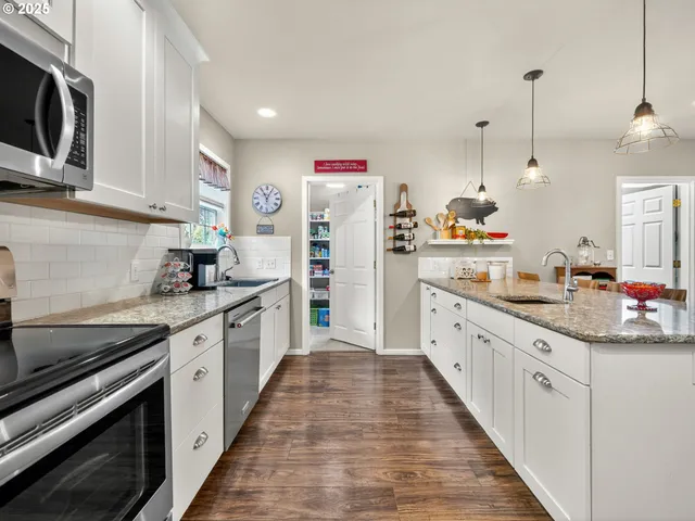 a kitchen with granite countertop cabinets stainless steel appliances and wooden floor