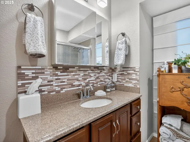 a bathroom with a granite countertop sink and a mirror