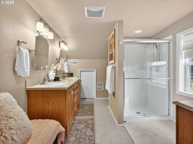 a bathroom with a double vanity sink mirror and shower