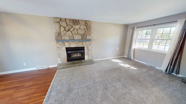 a view of an empty room with a fireplace and a window