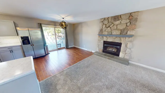 an empty room with windows and fireplace