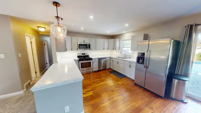 a large kitchen with cabinets and stainless steel appliances