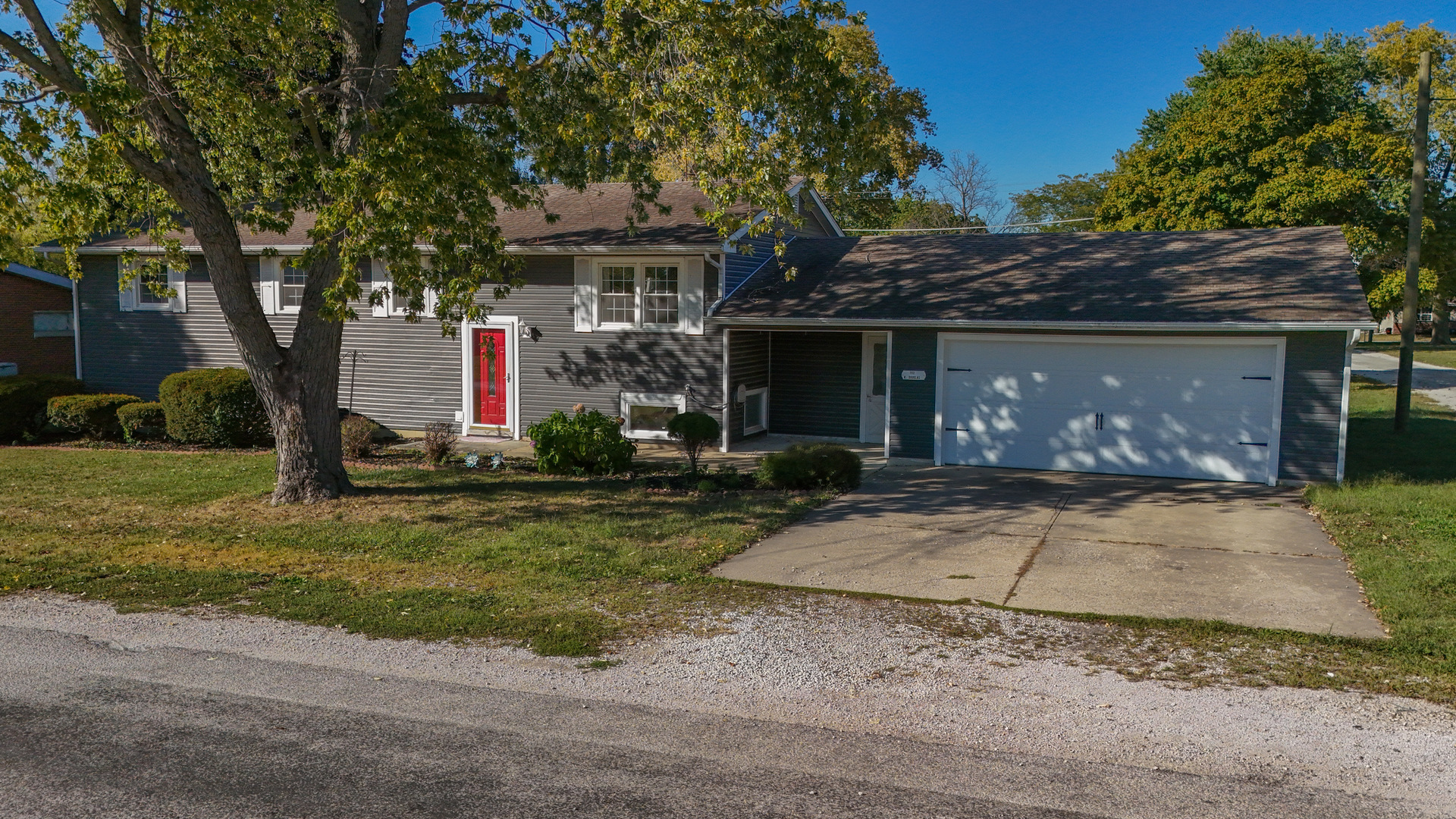 102 West Douglas Street St. Joseph, IL 61873 - Photo 3 of 27 a front view of a house with a yard and garage