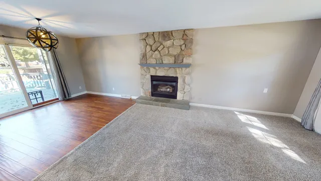 a view of an empty room with a fireplace and a window