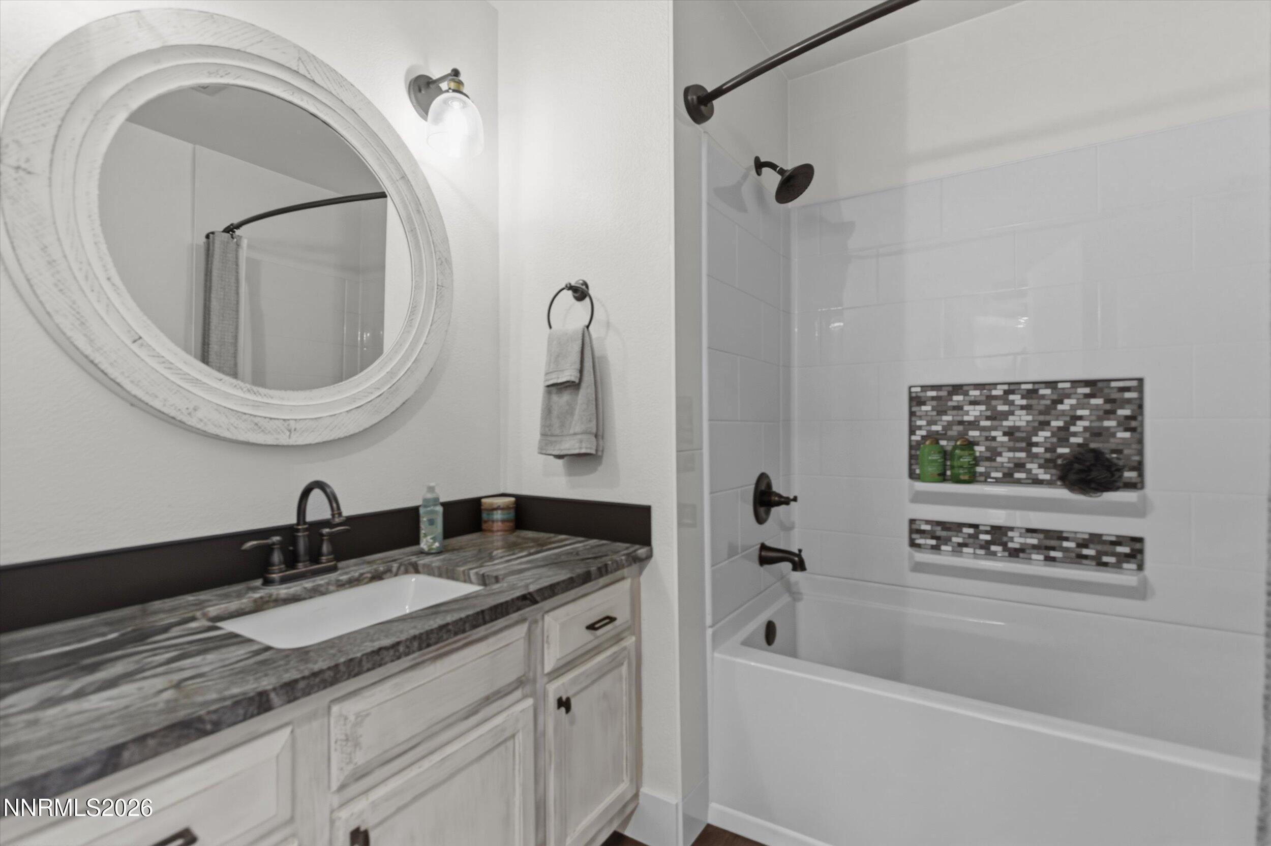 435 Kathy Terrace Sparks, NV 89436 - Photo 15 of 49 a bathroom with a granite countertop sink a mirror a vanity and a shower