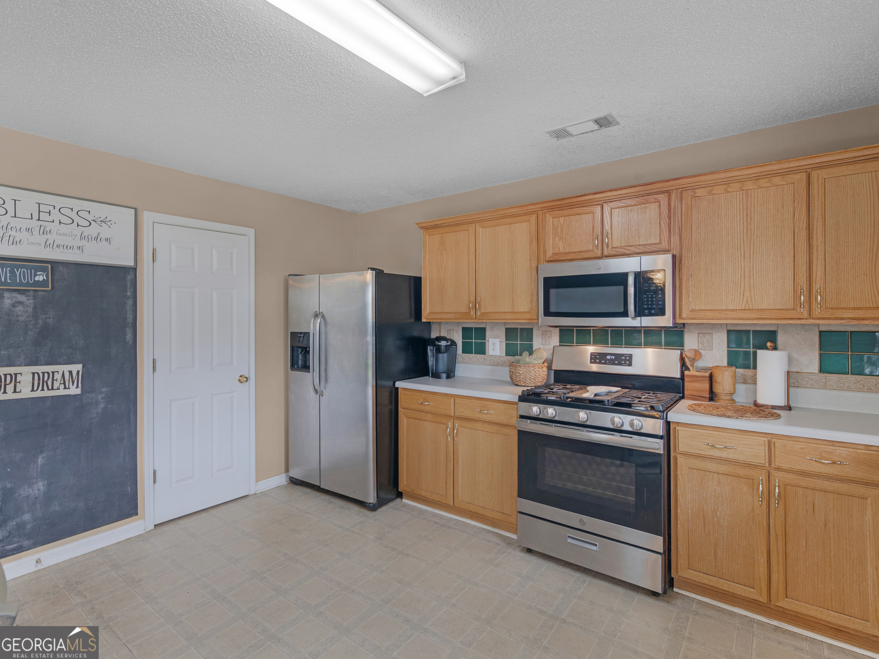 3370 Waggoner Place Rex, GA 30273 - Photo 12 of 25 a kitchen with white cabinets and stainless steel appliances