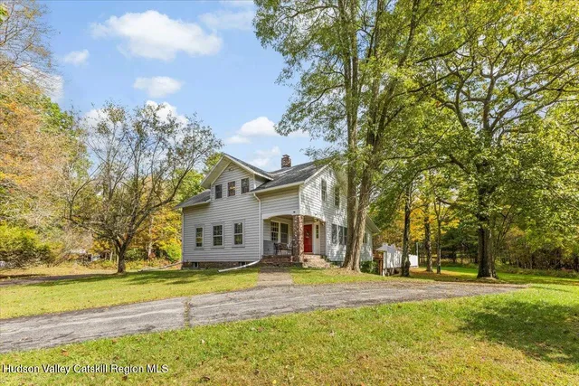 a view of a house with a big yard and large trees