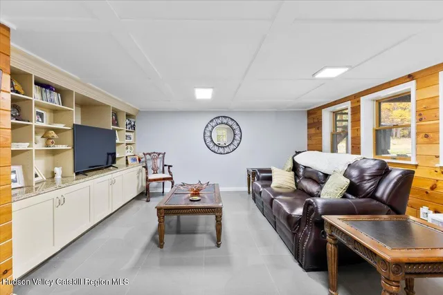 a living room with furniture a clock and a flat screen tv