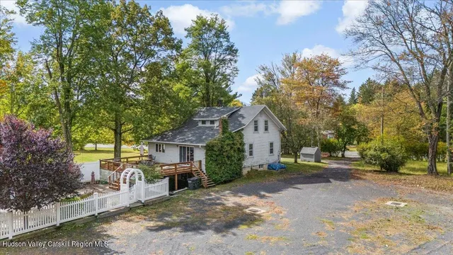 a view of a house with a yard and large trees