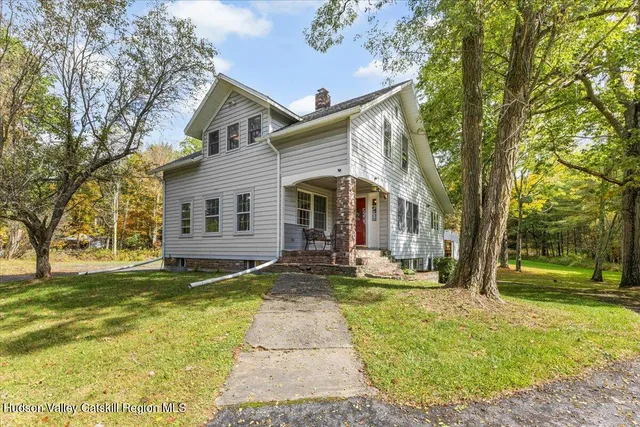 a view of a house with a yard and tree s