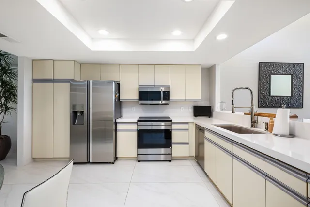a kitchen with stainless steel appliances granite countertop a refrigerator and a sink