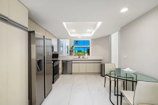 a kitchen with a refrigerator and white cabinets