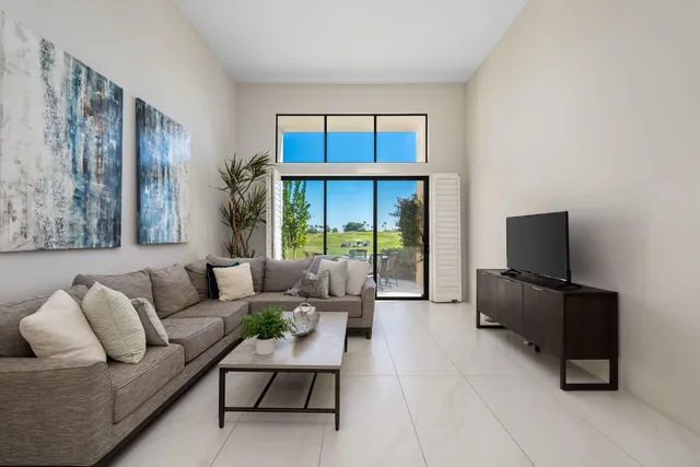 a living room with furniture and a floor to ceiling window