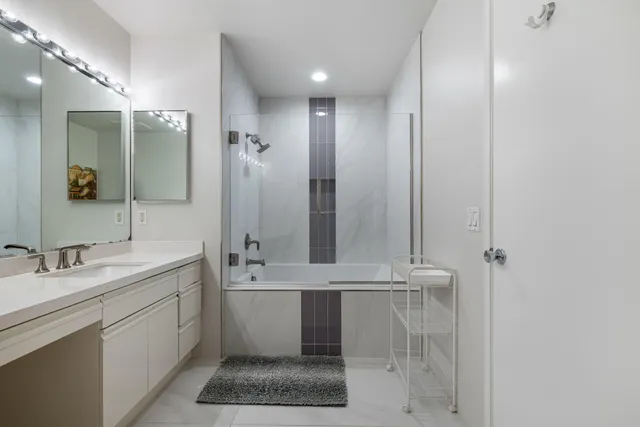 a bedroom with a bed a table and windows