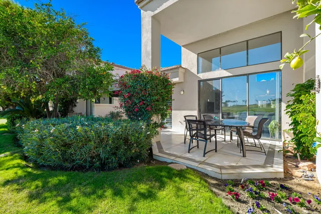 a view of a chair and table in backyard of the house