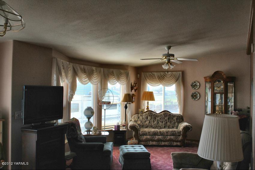 1100 Arrowsmith Road Sunnyside, WA 98944 - Photo 3 of 7 a living room with furniture a flat screen tv and a large window