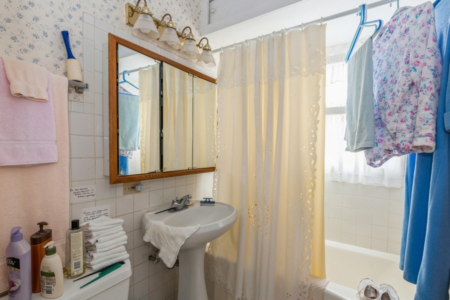 796 Green Bay Road Winnetka, IL 60093 - Photo 9 of 14 a bathroom with a sink and mirror with bathtub