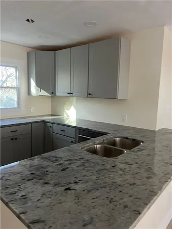a kitchen with granite countertop a sink and a stove
