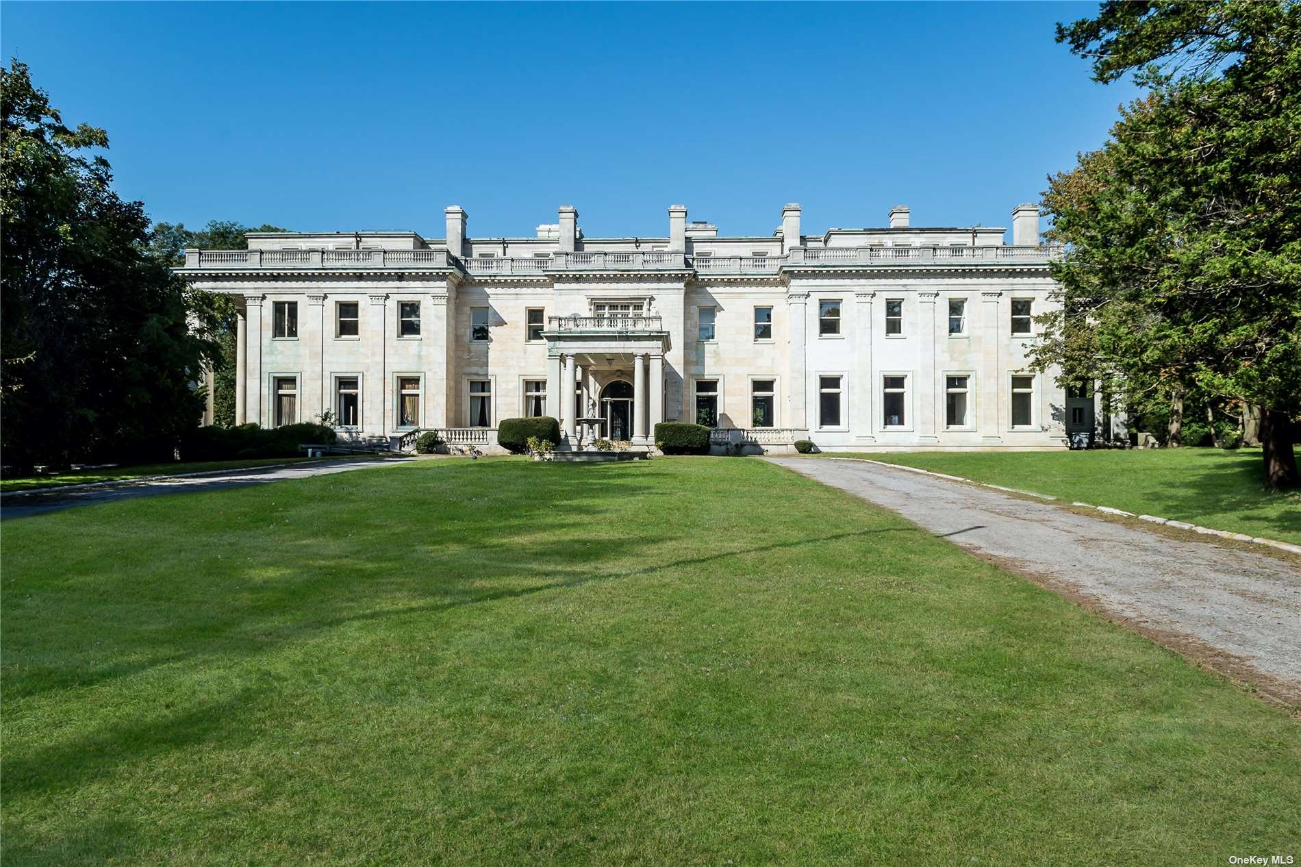 a large white building with a yard in front of it