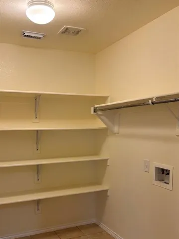 a view of walk in closet with empty racks