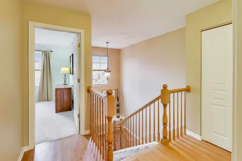 a view of a hallway with wooden floor and staircase