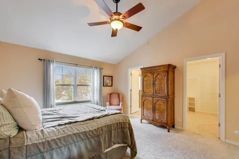 a bedroom with a bed and dresser with mirror