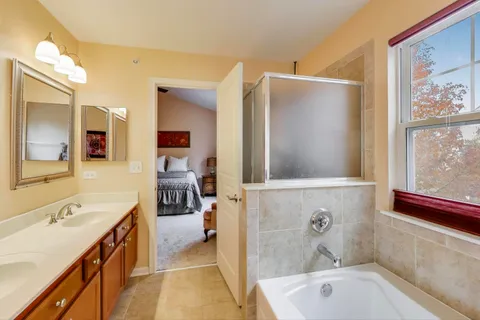 a spacious bathroom with a tub sink and mirror