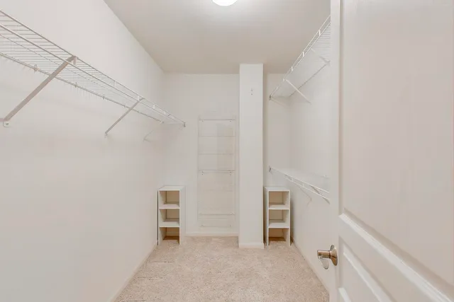 a view of walk in closet with empty racks