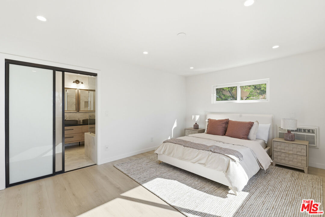 2442 South Coast Highway, Unit 3 Laguna Beach, CA 92651 - Photo 16 of 30 a bedroom with a large bed and a painting on the wall