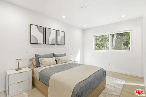 a bedroom with a large bed and a lamp on table