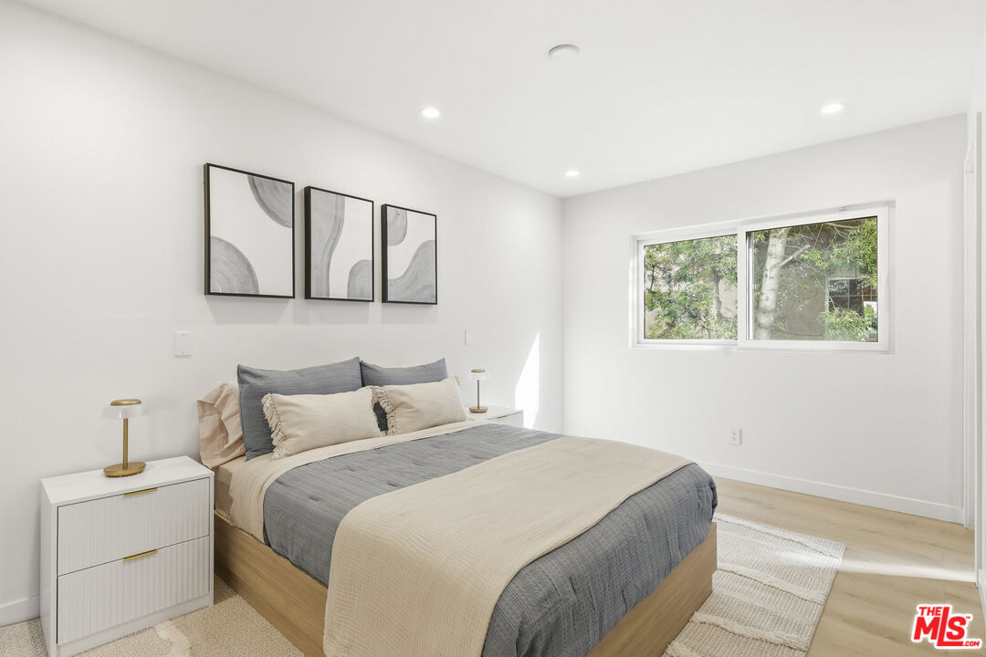 2442 South Coast Highway, Unit 3 Laguna Beach, CA 92651 - Photo 18 of 30 a bedroom with a large bed and a lamp on table