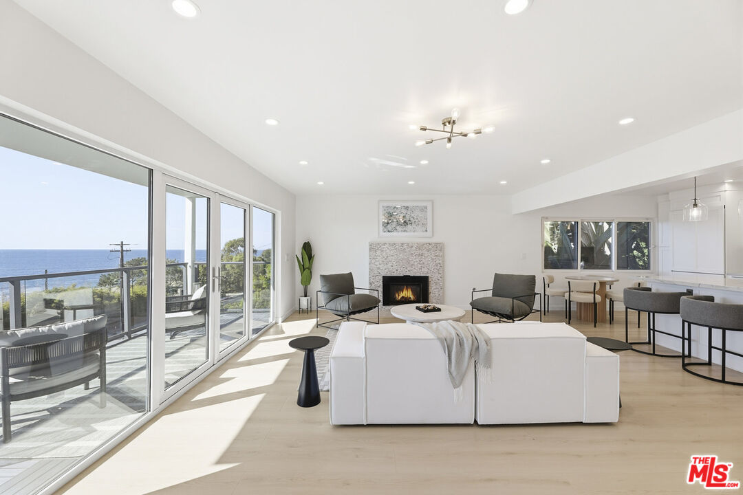 2442 South Coast Highway, Unit 3 Laguna Beach, CA 92651 - Photo 5 of 30 a living room with fireplace furniture and a large window