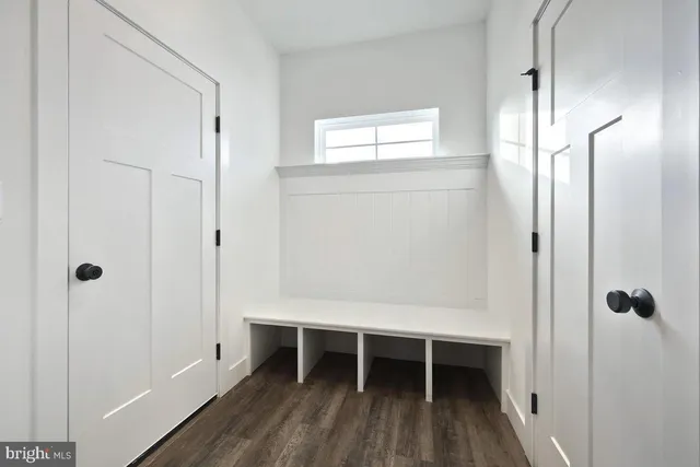 a view of a room with wooden floor and a bathroom