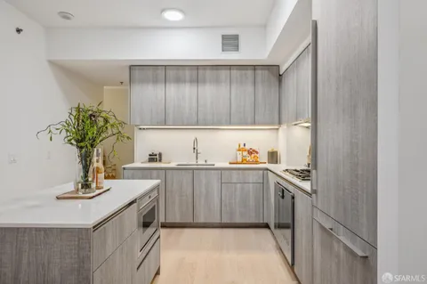 a view of living room kitchen with stainless steel appliances granite countertop lots of counter top space and furniture